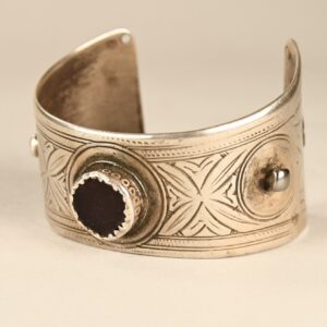 Antico bracciale berbero del gruppo etnico Ida Ou Semlal, in argento con perla di vetro scuro e smalti giallo scuro e verde, proveniente dall’Anti-Atlante marocchino.