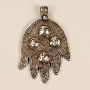 Pendente in argento raffigurante la mano di Fatima khamsa, simbolo di protezione e buona fortuna, decorato con incisioni e rilievi tradizionali.