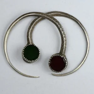 Antichi orecchini a cerchio Tuareg in argento finemente lavorati a mano, con incisioni sottili e perle di vetro incastonate rosso e verde scuro.