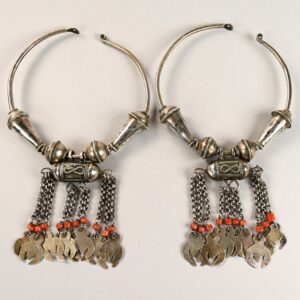 Antichi orecchini berberi a cerchio in argento con coralli e pendenti appesi a sottili catene sul bordo inferiore.
