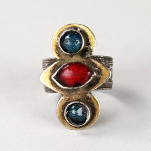 Antico anello turkmeno in argento dorato con vetri rossi e azzurro scuro incastonati sulla parte frontale.