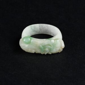 Anello cinese a fascia in giada naturale con raffigurazioni vegetali finemente incise.