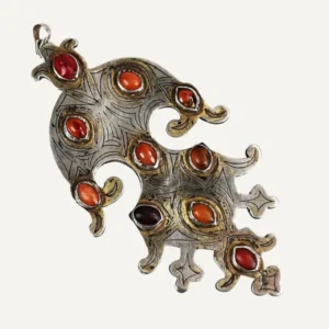 Pendente turkmeno Dagdan della trib&ugrave; Teke, con cabochon di corniola, inserti in vetro verde e decorazione simmetrica a forma di rapaci, 15,5 &times; 8 cm.